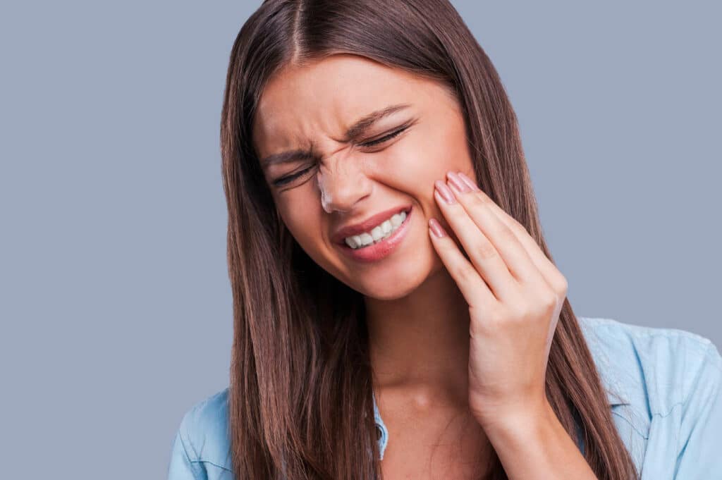 Warum tun Zähne nach dem Bleaching weh - Titelbild Frau mit Zahnschmerzen nach Bleaching